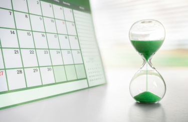 grüne Sanduhr vor Rechner