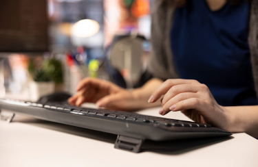 Frau tippt auf einer Tastatur