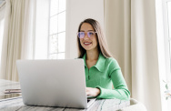 Frau mit Brille arbeitet am Laptop