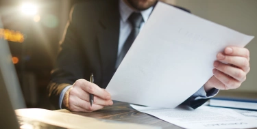 Geschäftsmann, der am Schreibtisch mit Dokumentation arbeitet
