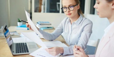 2 Frauen arbeiten am Schreibtisch