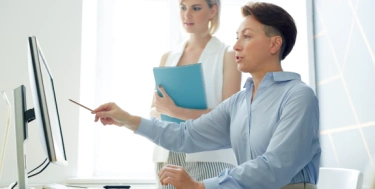 2 Frauen am Rechner die etwas besprechen