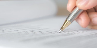 Hand mit Stift über Bewerbungsformular