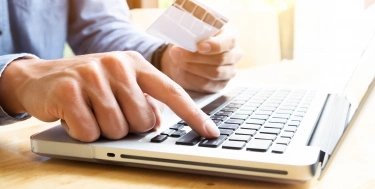 Mann tippt auf einem Laptop