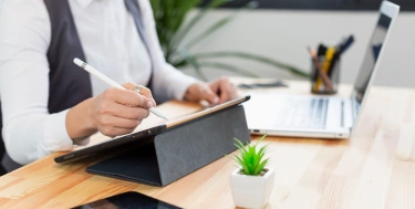Nahaufnahmeperson, die auf Tablette arbeitet