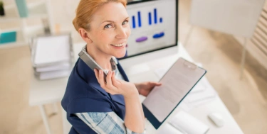 Frau bei der Arbeit im Büro am Schreibtisch mit Rechner und Zahlen