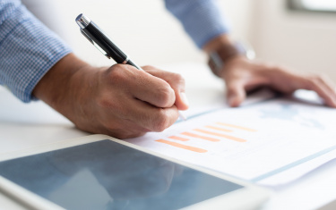 Nahaufnahme eines Mannes, der Geschäftsdaten analysiert