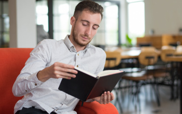 Fokussiertes Kerllesebuch auf Sofa in der Lobby