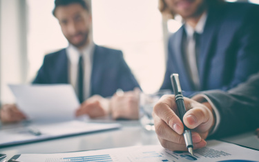 Nahaufnahme der Hand einer Führungskraft, die ein Diagramm überprüft