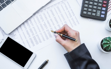  Hand, die Füllfederhalter am Schreibtisch hält