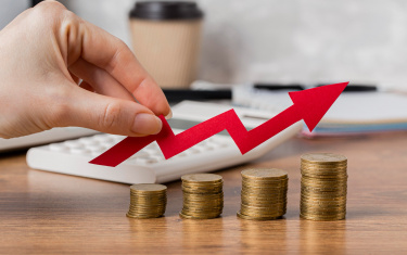 Hand, die Wachstumspfeil mit Münzen hält