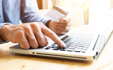 Mann tippt auf einem Laptop